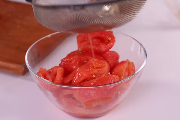 Dùng rây để loại bỏ phần hạt cà chua
